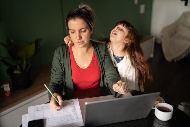 Mid adult woman trying to work with daughter at home (Photo: FG Trade via Getty Images)