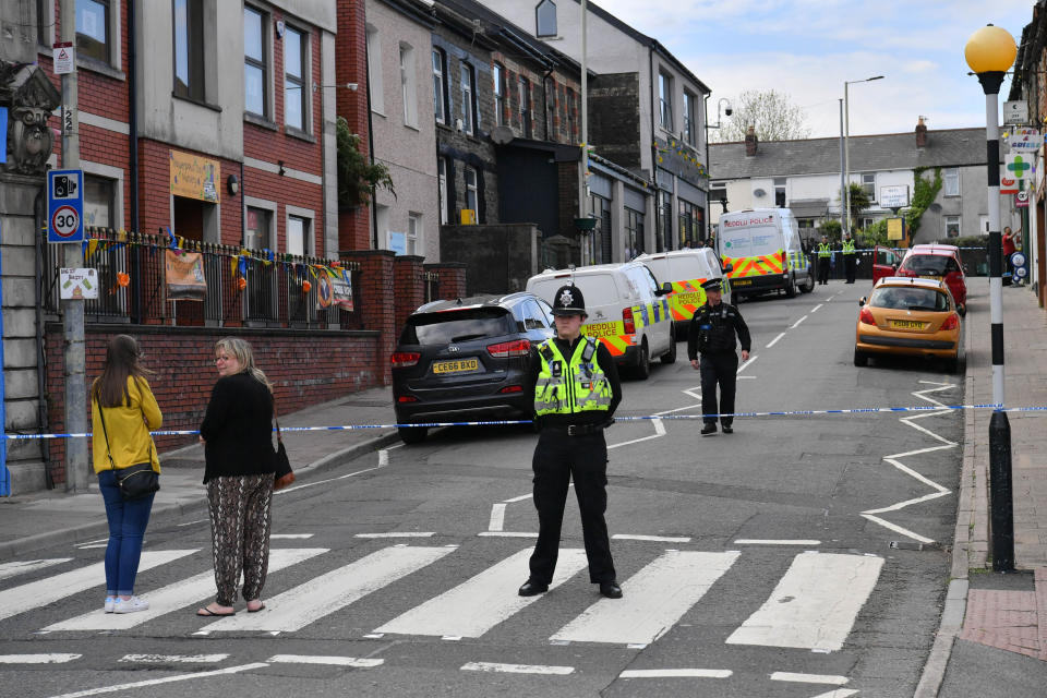 Police at the scene of a reported stabbing in the village of Pen Y Graig in South Wales.