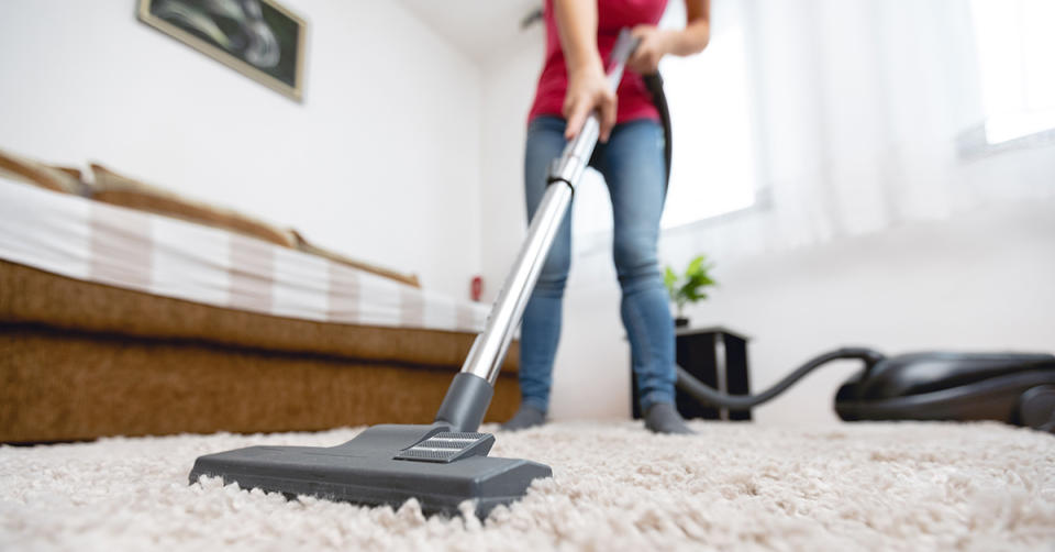 Woman vacuum cleaning her room