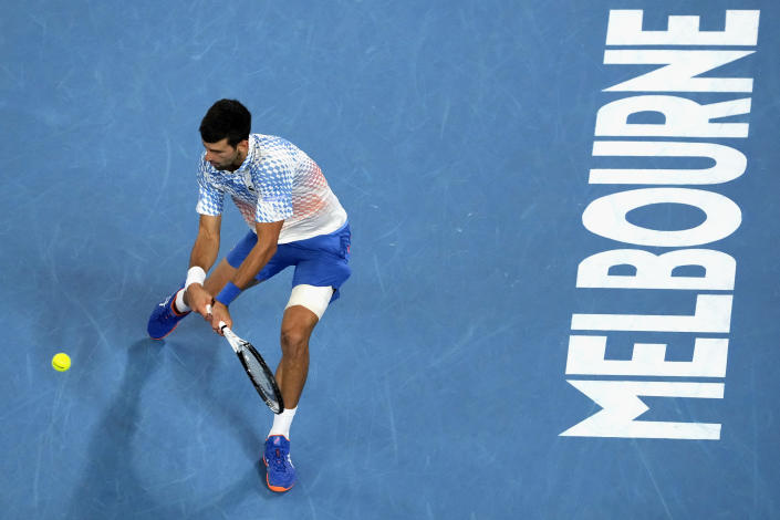 Novak Djokovic of Serbia plays a backhand return to Andrey Rublev of Russia during their quarterfinal match at the Australian Open tennis championship in Melbourne, Australia, Wednesday, Jan. 25, 2023. (AP Photo/Aaron Favila)