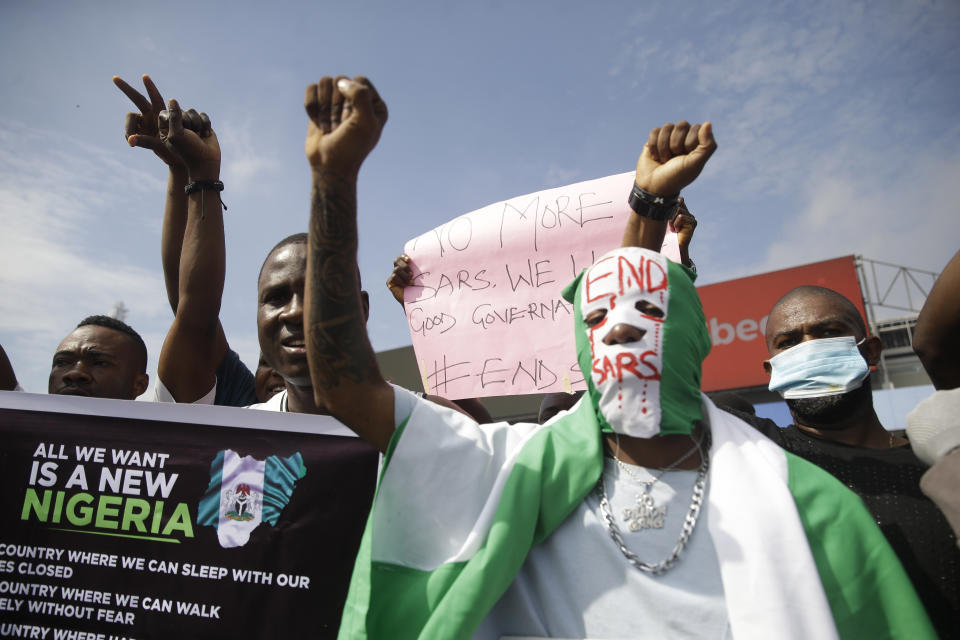 FILE- In this Sunday Oct. 18, 2020 file photo, People hold banners as they demonstrate on the street to protest against police brutality in Lagos, Nigeria, Sunday, Oct. 18, 2020. In a report submitted to Lagos Governor Babajide Sanwo-Olu on Monday, Nov. 15, 2021, a Nigerian judicial panel has found that soldiers of the Nigerian army "shot, injured and killed" protesters during the Oct. 2020 nationwide demonstrations against police brutality in the country's most populous city Lagos. (AP Photo/Sunday Alamba, File)