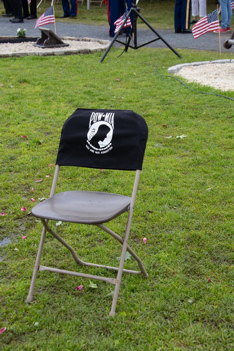 A chair covered with POW-MIA flag honors those missing at a Memorial Day service.