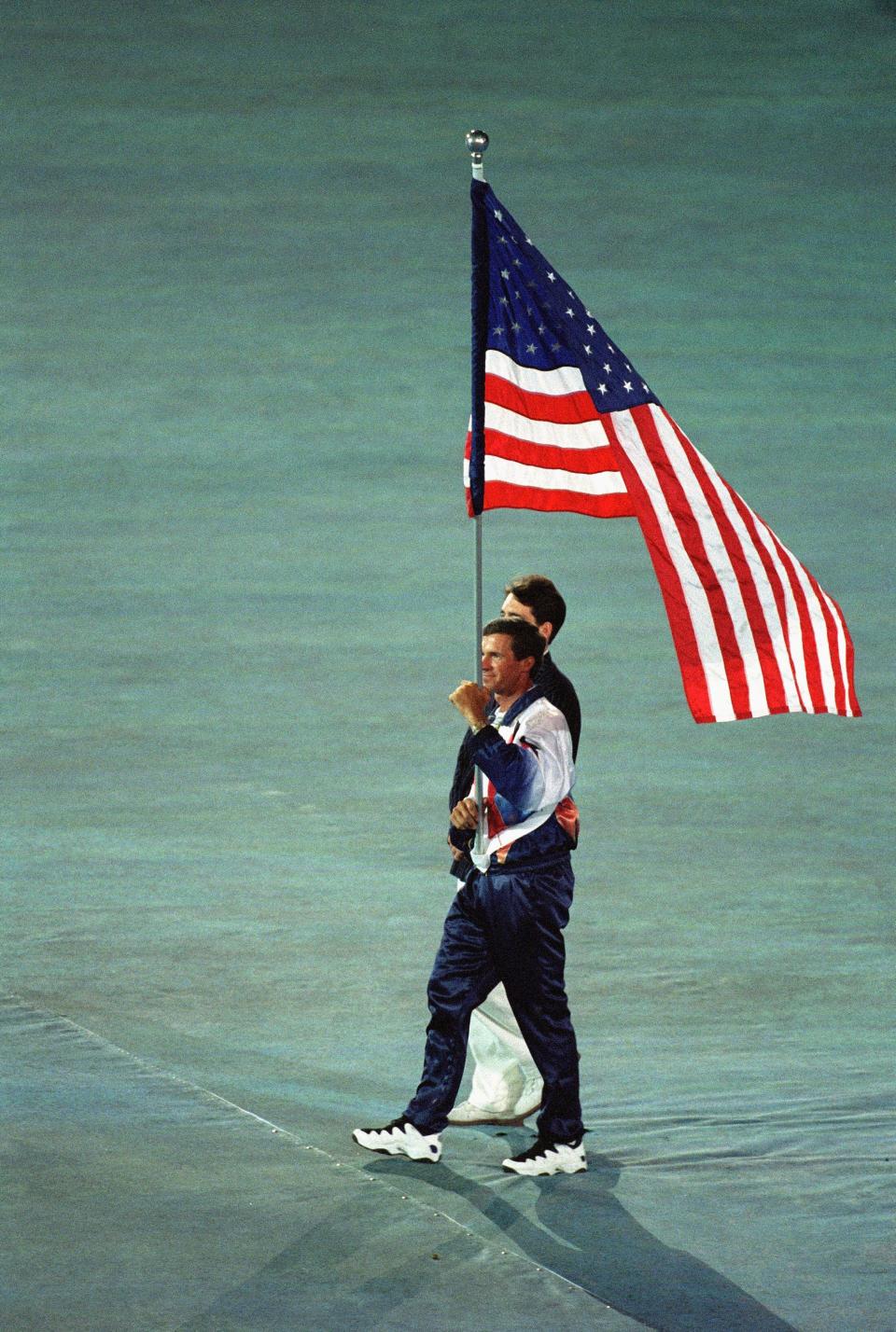 Michael Matz of the USA Equestrian Team carries the American flag on the field during closing ceremonies at Olympic Stadium on August 4, 1996 during the Atlanta 1996 Olympic Games in Atlanta, Georgia.