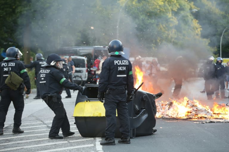 Riot police move a burning bin during the "Welcome to Hell" rally against the G20 summit in Hamburg, northern Germany on July 6, 2017