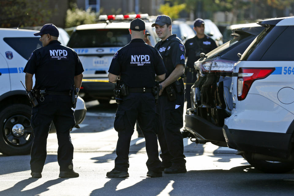 Emergency personnel stand near the scene of a fatal shooting of a police officer in the Bronx borough of New York, Sunday, Sept. 29, 2019. (AP Photo/Seth Wenig)