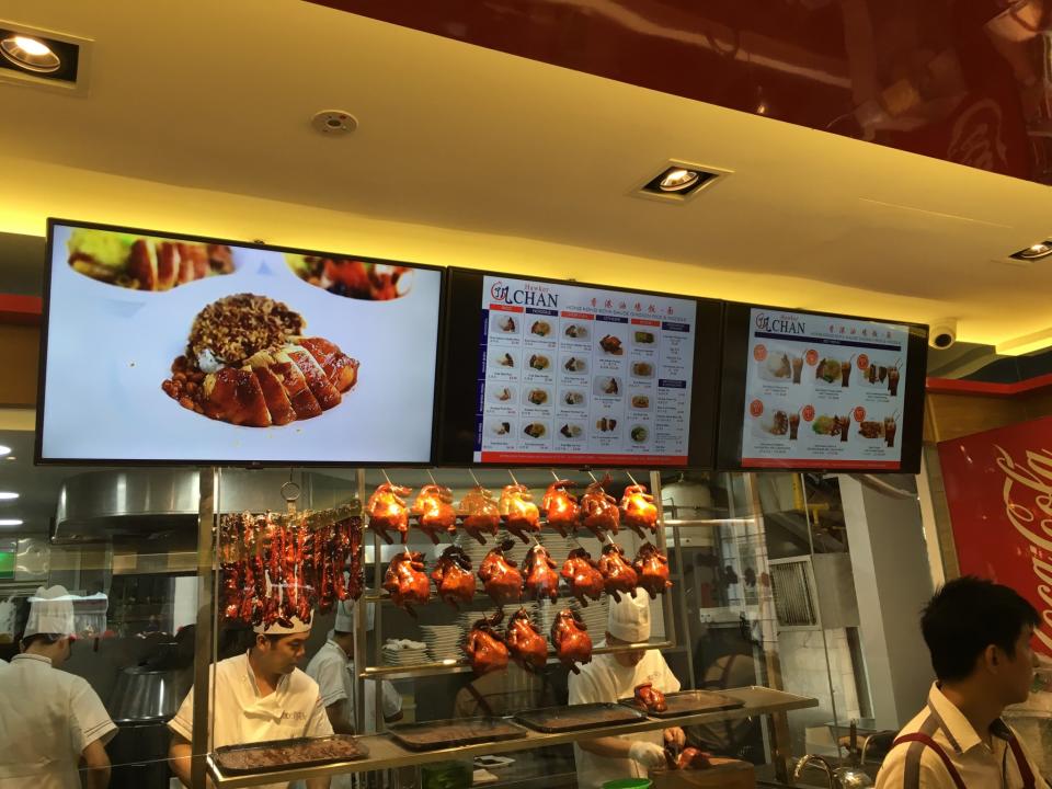 <p>Electronic menu boards welcome customers at Hawker Chan. </p>