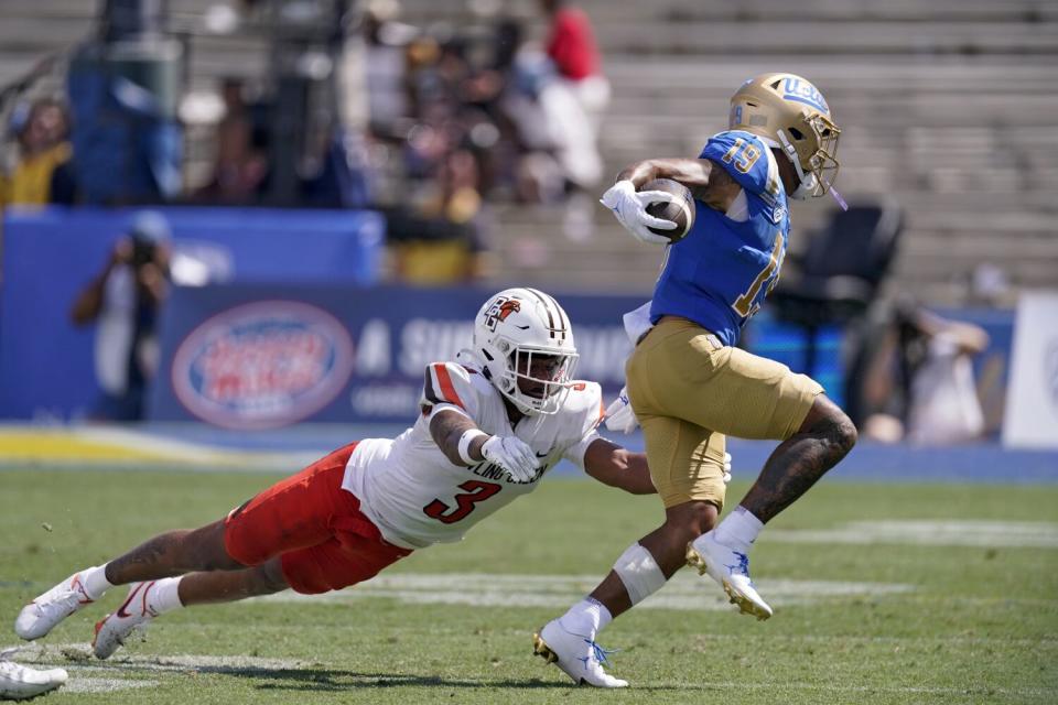 UCLA wide receiver Kazmeir Allen runs the ball as Bowling Green safety Chris Bacon attempts a tackle.