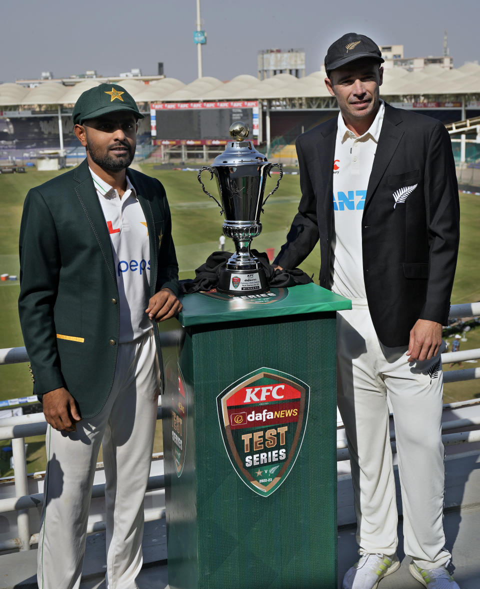 Pakistani skipper Babar Azam, left, and his New Zealand's counterpart Tim Southee pose for a photo with the test series trophy, in Karachi, Pakistan, Sunday, Dec. 25, 2022. (AP Photo/Fareed Khan)