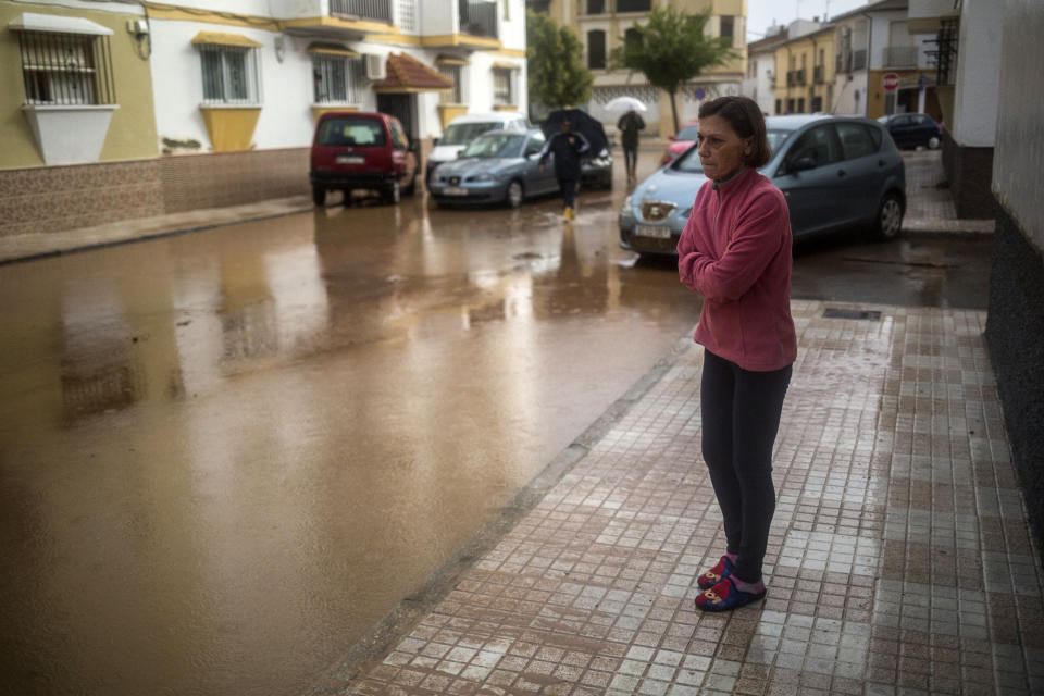 A woman observes damage caused by floods in the village of Campillos, Spain, where heavy rain and floods have caused severe damage and the death of a firefighter according to Spanish authorities Sunday, Oct. 21 2018. Emergency services for the southern region of Andalusia say that the firefighter went missing when his truck overturned on a flooded road during heavy rains that fell through the night, and his body was found after a search Sunday morning.(AP Photo/Javier Fergo)