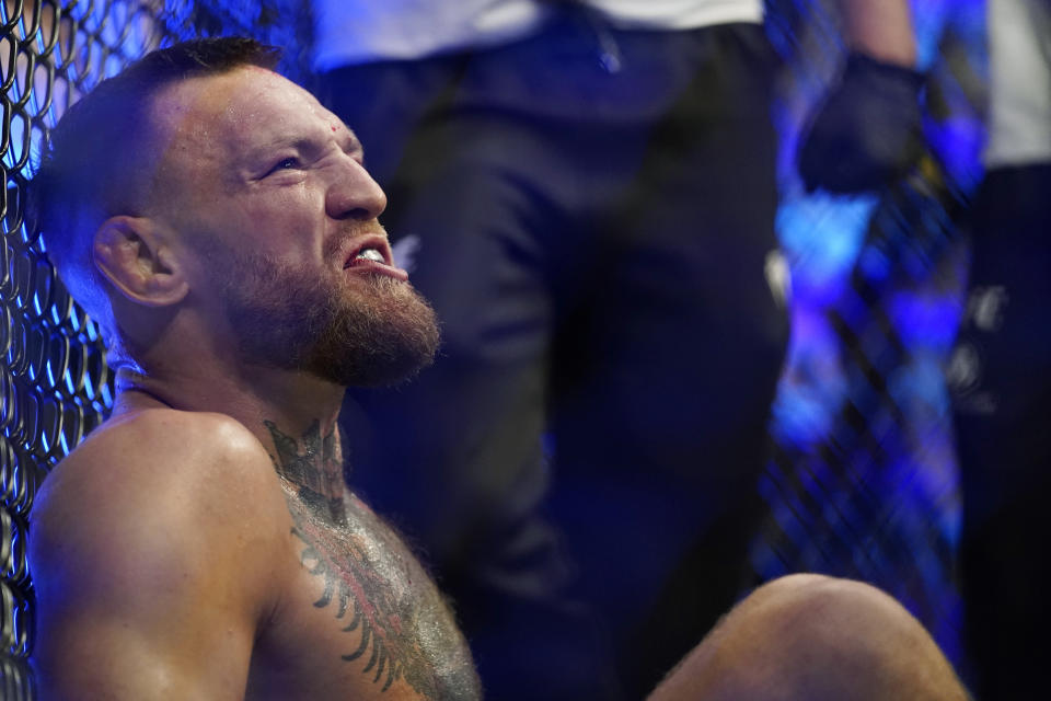 Conor McGregor sits while receiving attention for injury while fighting Dustin Poirier in a UFC 264 lightweight mixed martial arts bout Saturday, July 10, 2021, in Las Vegas. (AP Photo/John Locher)