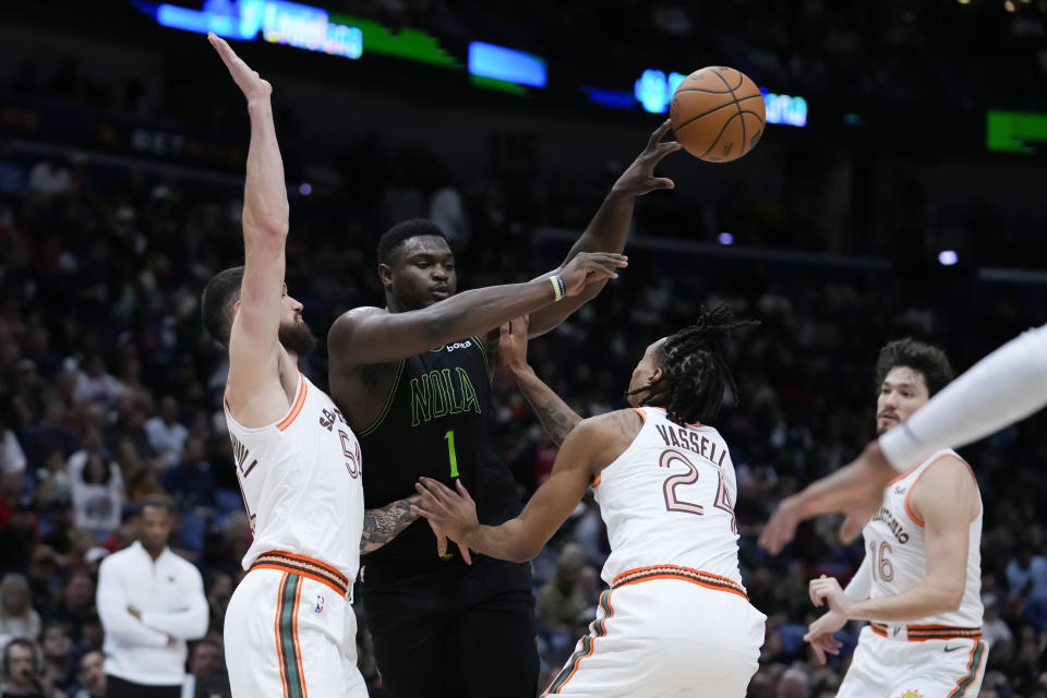 New Orleans Pelicans forward Zion Williamson (1) passes between San Antonio Spurs guard Devin Vassell (24) and forward Sandro Mamukelashvili in the first half of an NBA basketball game in New Orleans, Friday, Dec. 1, 2023. (AP Photo/Gerald Herbert)