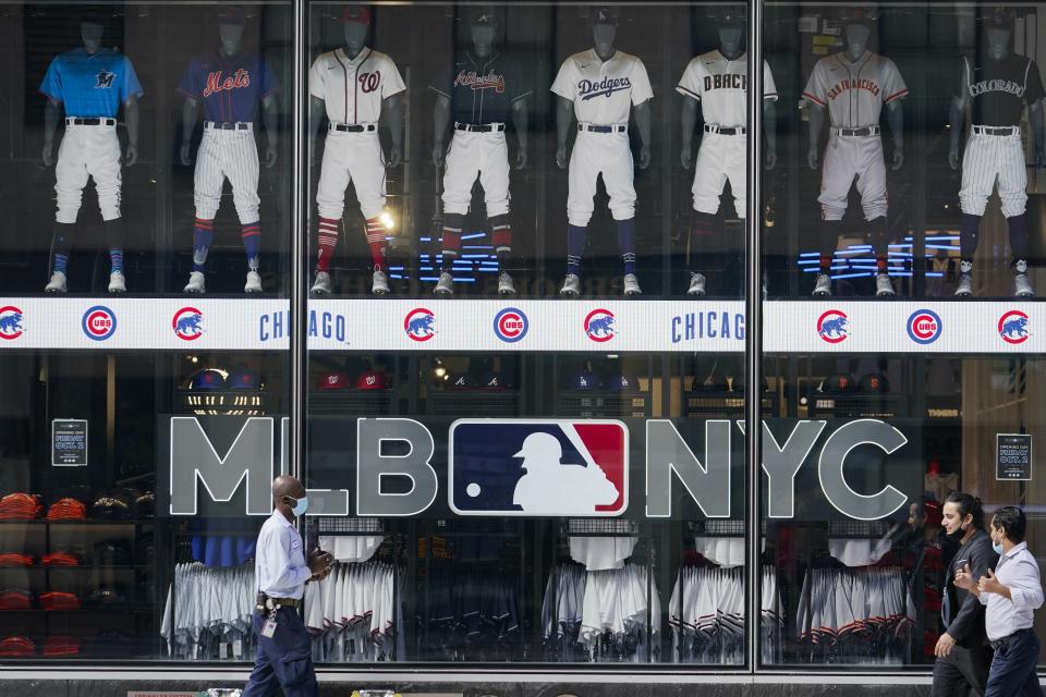 Pedestrians pass the MLB Flagship store Wednesday, Sept. 30, 2020, in New York. The two-floor store is in the space formerly occupied by the studio of the New York Mets’ SNY regional sports network. (AP Photo/Frank Franklin II)