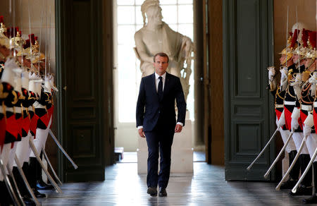 FILE PHOTO: French President Emmanuel Macron walks through the Galerie des Bustes (Busts Gallery) to access the Versailles Palace's hemicycle to address both the upper and lower houses of the French parliament (National Assembly and Senate) at a special session in Versailles near Paris, France, July 9, 2018. REUTERS/Charles Platiau/File Photo