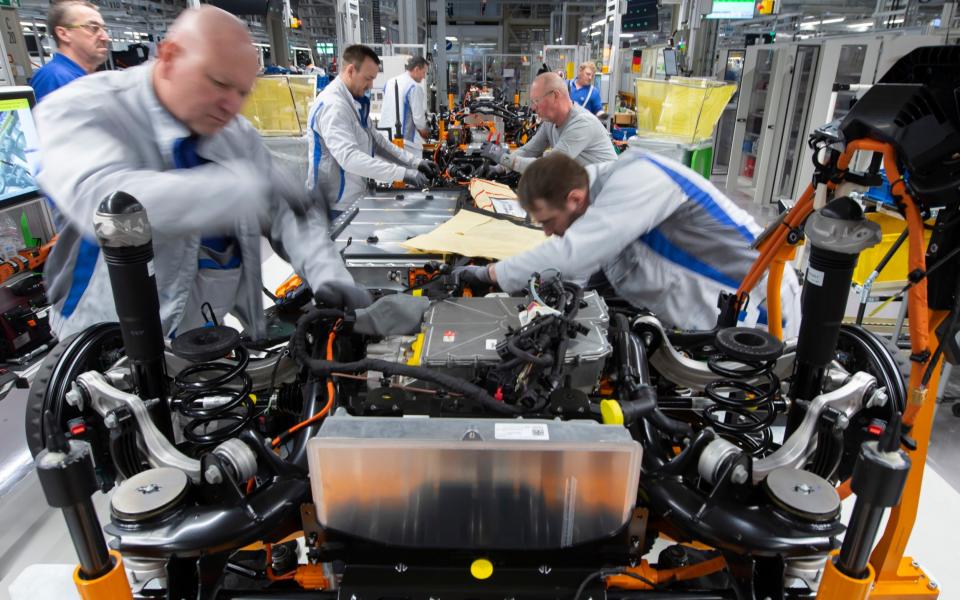 Workers complete a Volkswagen ID.3 electric car body at the assembly line in Zwickau, 2020