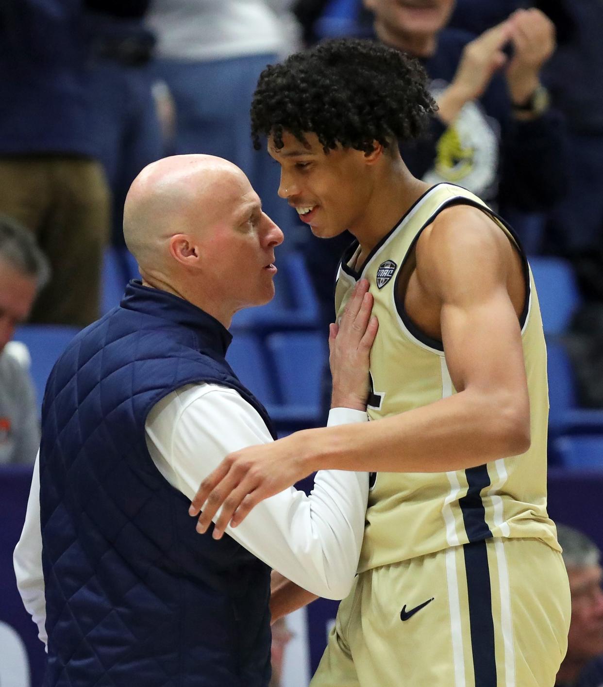 Akron Zips forward Enrique Freeman (25) celebrates with head coach John Groce as the Zips lead late in the second half of an NCAA college basketball game against the Bradley Braves, Tuesday, Dec. 5, 2023, in Akron, Ohio.