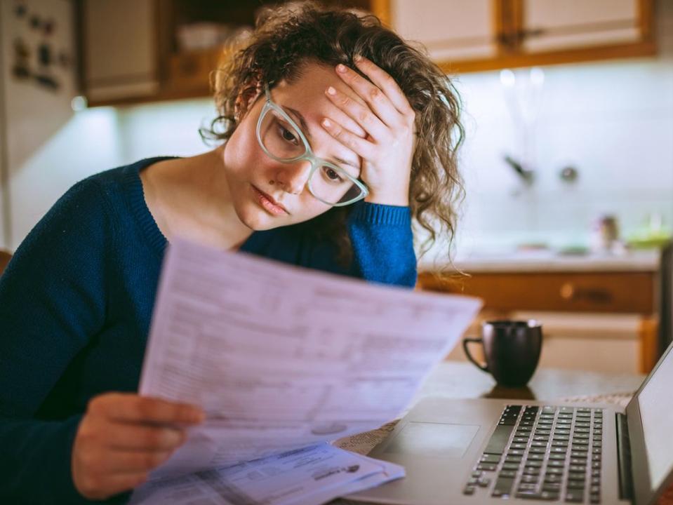 Woman going through bills, looking worried