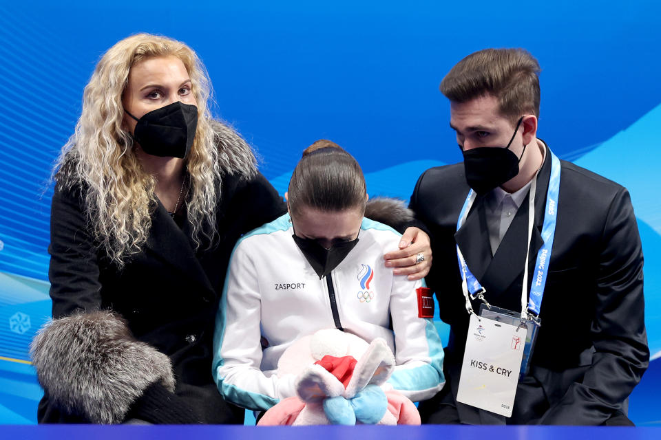 BEIJING, CHINA - FEBRUARY 17: Kamila Valieva of Team ROC reacts to their score with choreographer Daniil Gleikhengauz (R) and coach Eteri Tutberidze (L) after the Women Single Skating Free Skating on day thirteen of the Beijing 2022 Winter Olympic Games at Capital Indoor Stadium on February 17, 2022 in Beijing, China.  (Photo by Matthew Stockman/Getty Images)