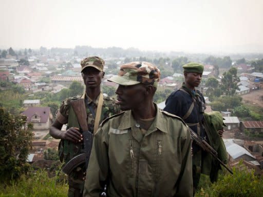 Colonel Sultani Makenga (C), head of the rebel M23 group, walks on a hill in Bunagana, a town near the Ugandan border. Rebel fighters in the Democratic Republic of Congo seized control Sunday of more towns in the country's east, but said they would cede most of their gains to UN peacekeepers and police