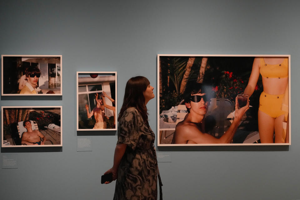 A visitor looks at pictures during a preview of Paul McCartney Photographs 1963-64: Eyes of the Storm exhibition at the National Portrait Gallery in London, Britain, Tuesday, June 27, 2023. The exhibition consists of unseen photographs taken by Paul McCartney from the Beatles at the height of Beatlemania. The gallery will open it's doors from June 28, 2023 until October 1, 2023. (AP Photo/Frank Augstein)