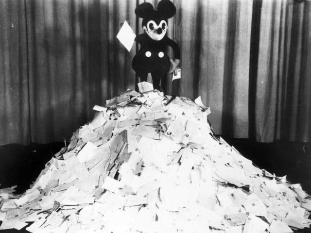 Micky Mouse on top of a pile of papers