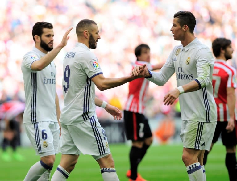 Real Madrid's forward Karim Benzema (C) is congratulated by teammates Cristiano Ronaldo (R) and defender Nacho Fernandez after scoring on March 18, 2017