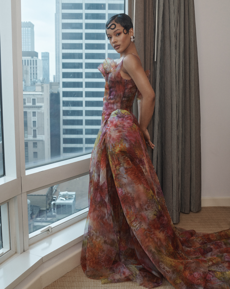 a woman wearing a floral dress in a hotel suite