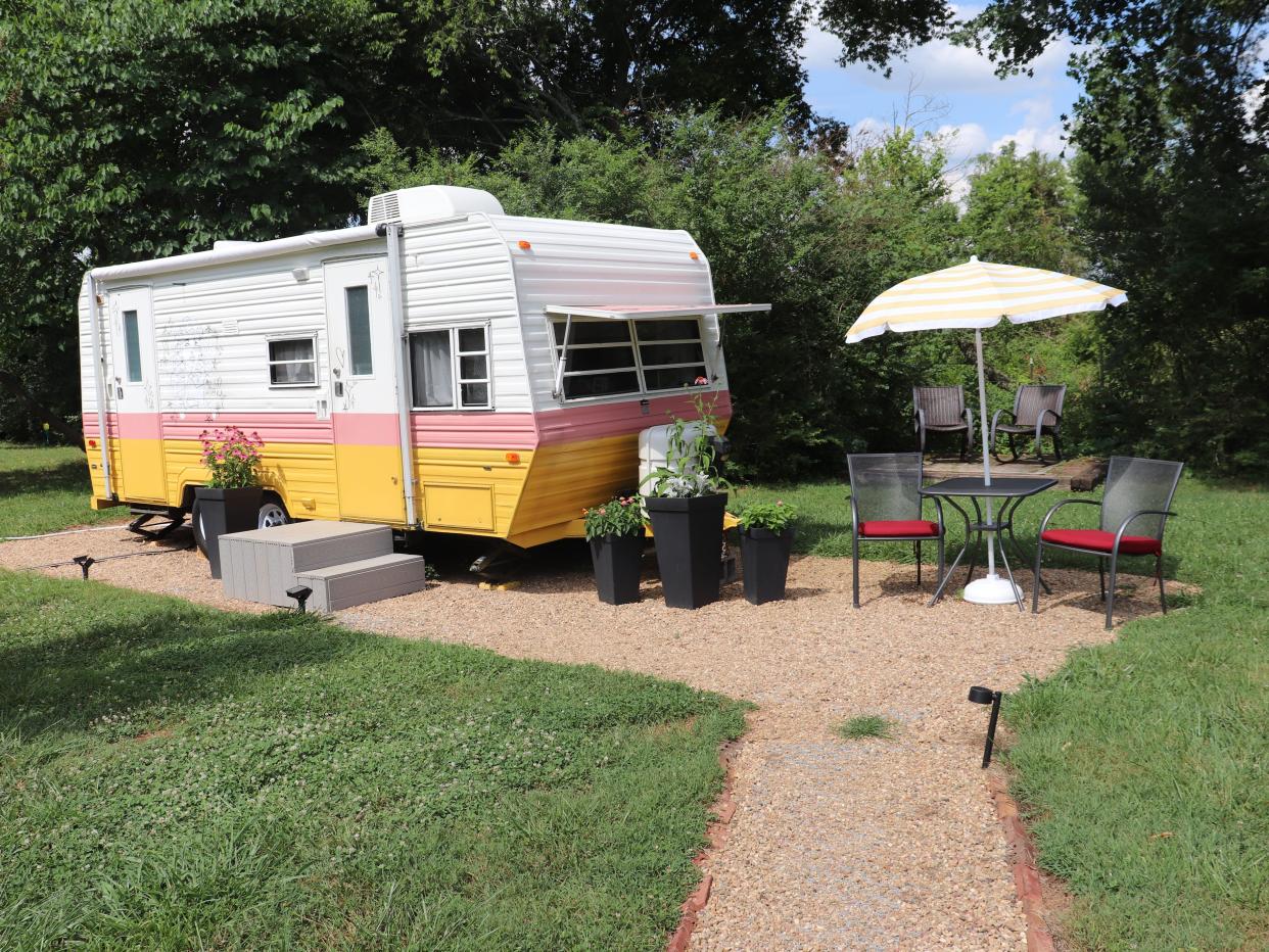 A Dolly Parton-themed RV on Airbnb with a small outdoor seating area next to it.