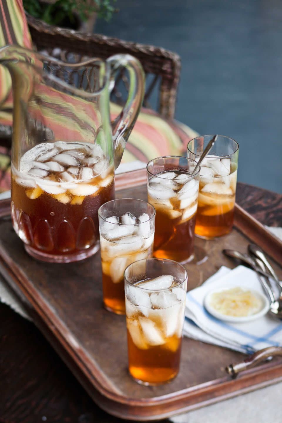 ginger iced tea in glasses on a tray with a pitcher of tea
