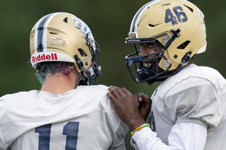 Gallaudet fullback Jahson Welch, right, laughs with wide receiver Keanu Herzig-Wilcox, left, during football practice at Hotchkiss Field, Tuesday, Oct. 10, 2023, in Washington. (AP Photo/Stephanie Scarbrough)