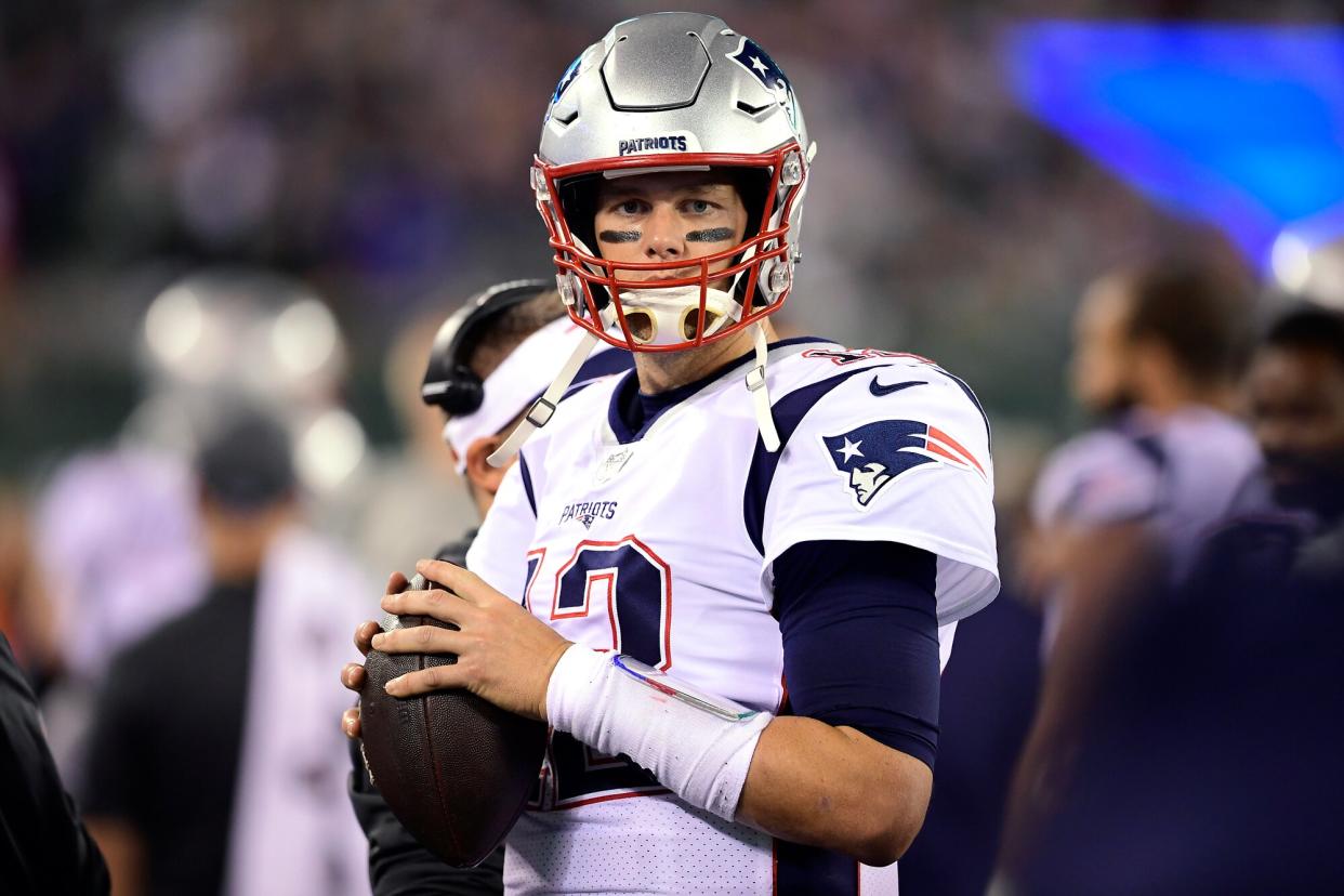 Tom Brady #12 of the New England Patriots warms up on the sidelines before returning to the game against the New York Jets at MetLife Stadium on October 21, 2019 in East Rutherford, New Jersey.