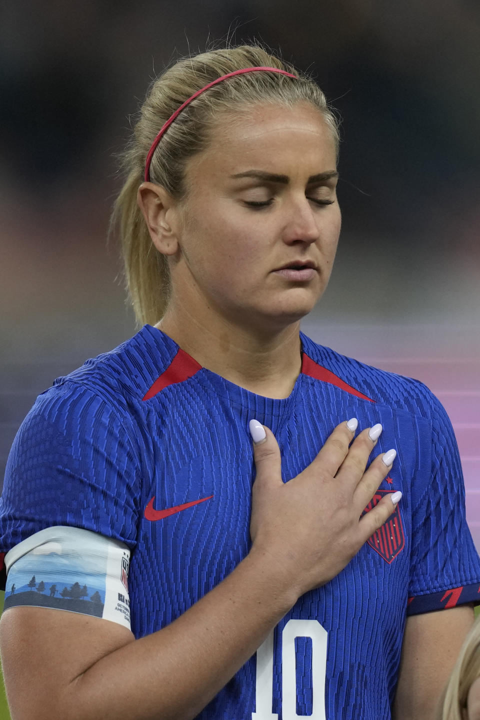U.S. midfielder Lindsey Horan puts her hand over her heart during the national anthem before the team's international friendly soccer match against Colombia on Thursday, Oct. 26, 2023, in Sandy, Utah. (AP Photo/Rick Bowmer)