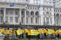 Greenpeace activists hold banners in the yard of Romania's Parliament, during a protest against a Canadian company's plan to set up Europe's biggest open-cast gold mine in Romania, in Bucharest December 9, 2013. A special Romanian parliament commission overwhelmingly rejected a draft bill that would have allowed Canada's Gabriel Resources to set up Europe's biggest open-cast gold mine in the small Carpathian town of Rosia Montana last month. However, parliament plans to revise a mining law that could open way for the project. REUTERS/Bogdan Cristel (ROMANIA - Tags: ENVIRONMENT SOCIETY CIVIL UNREST BUSINESS)