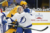 Tampa Bay Lightning center Yanni Gourde, front, falls to the ice after calling with Nashville Predators center Ryan Johansen (92) in the second period of an NHL hockey game Saturday, April 10, 2021, in Nashville, Tenn. (AP Photo/Mark Humphrey)