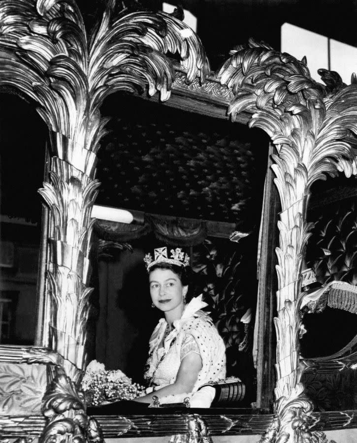 Queen Elizabeth II peeks out from the window of a state coach on her way to Westminster Abbey for her coronation ceremony on June 2, 1953. The Queen ascended the throne after her father King George VI passed away in February 1952 at age 56. Elizabeth was 27 years old.
