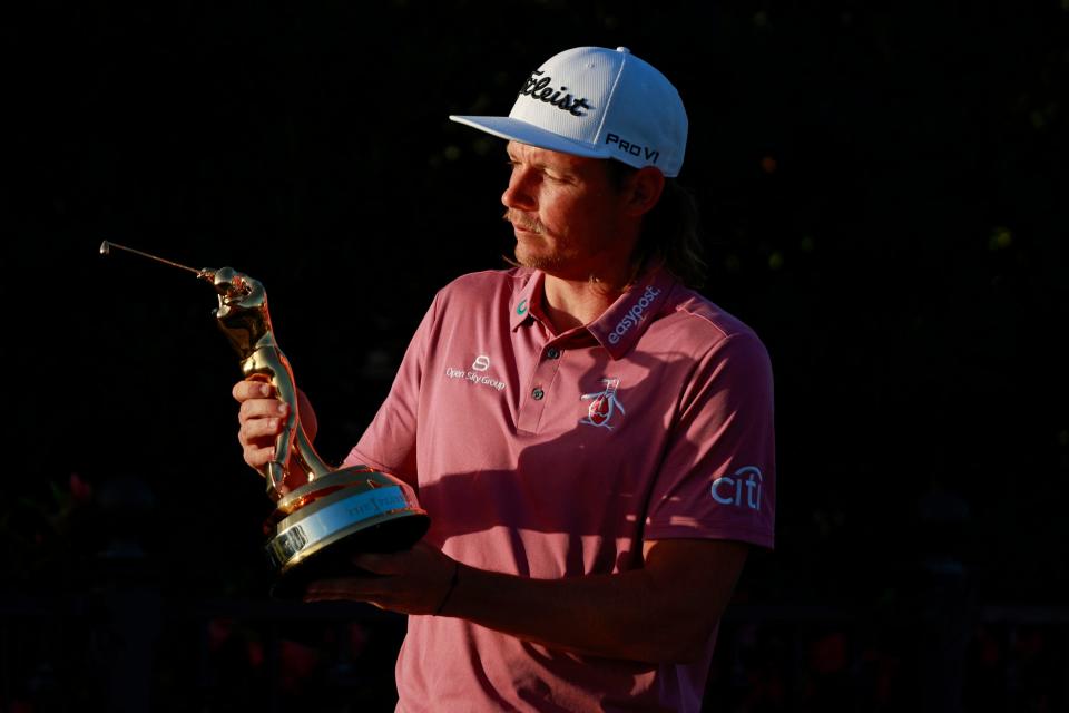 Cameron Smith admires the "Gold Man" Trophy he earned in March for winning The Players Championship.