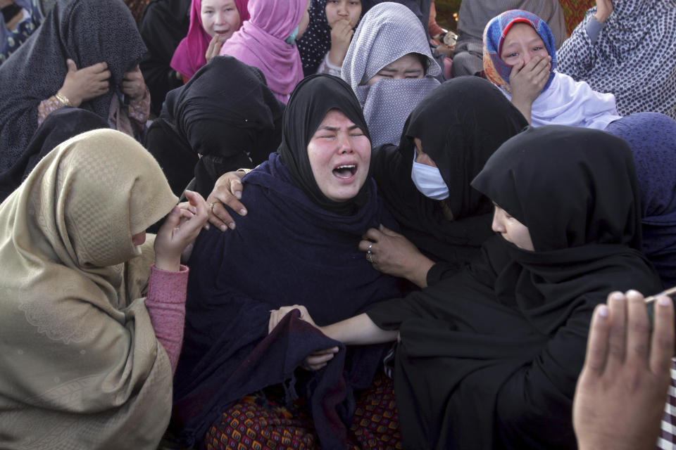 Women from the Shiite Hazara community mourn over death of their family members during at a sit-in protest against the killing of coal mine workers by unknown gunmen near the Machh coal field, in Quetta, Pakistan, Monday, Jan. 4, 2021. Gunmen opened fire on a group of minority Shiite Hazara coal miners after abducting them, killing 11 in southwestern Baluchistan province early Sunday, a Pakistani official said. (AP Photo/Arshad Butt)