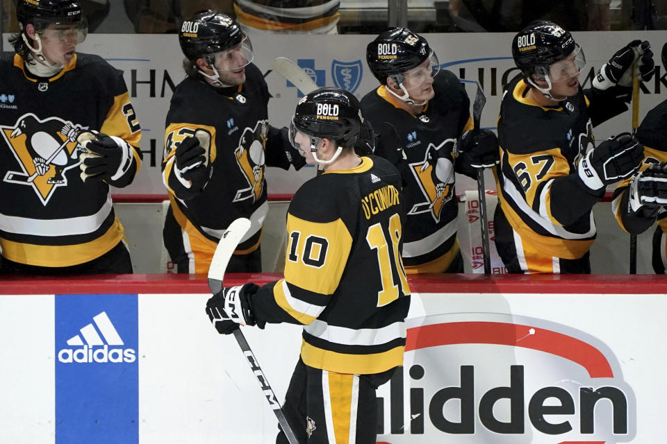 Pittsburgh Penguins' Drew O'Connor (10) returns to the bench after scoring against the St. Louis Blues during the first period of an NHL hockey game Saturday, Dec. 30, 2023, in Pittsburgh. (AP Photo/Matt Freed)
