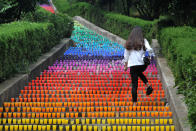 <p>A woman walks on steps lined with plastic cups, an art project of four college students, in Wuhan, Hubei Province, China, May 24, 2016. (Stringer/REUTERS) </p>