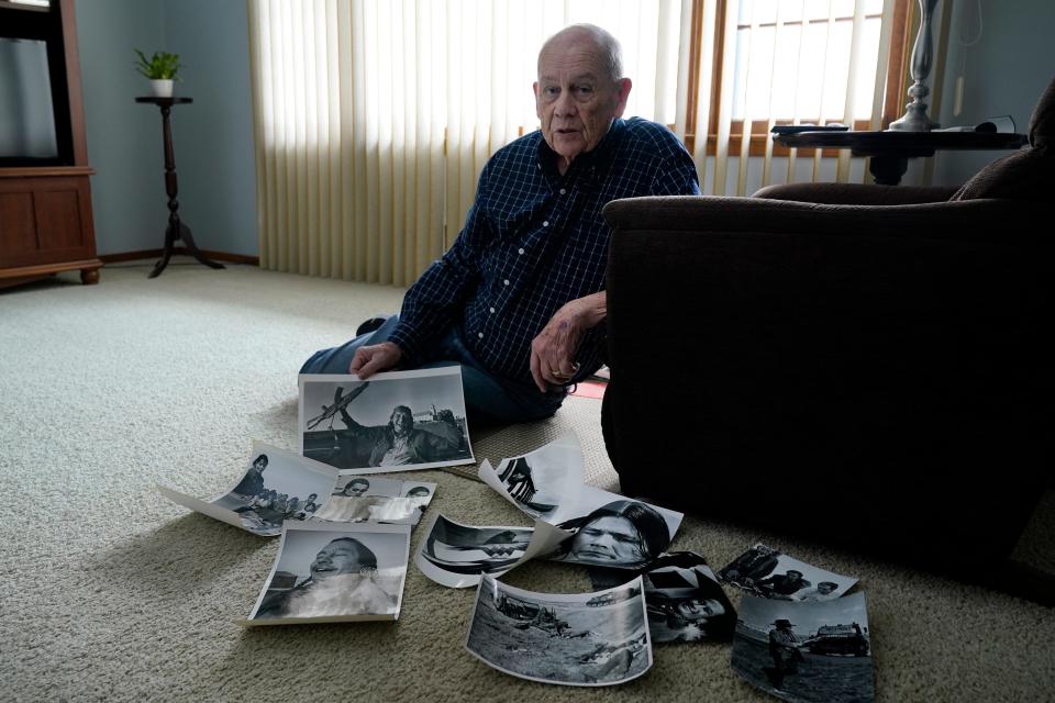 Retired Associated Press Photographer Jim Mone sits with prints of his photos taken from his coverage at Wounded Knee, Friday, Feb. 24, 2023, in Bloomington, Minn. On Feb. 27, 1973, members of the American Indian Movement took over the town of Wounded Knee, starting a 71-day occupation on the Pine Ridge Indian Reservation in South Dakota. Mone was there to capture images of the standoff as it stretched into weeks. (AP Photo/Abbie Parr)