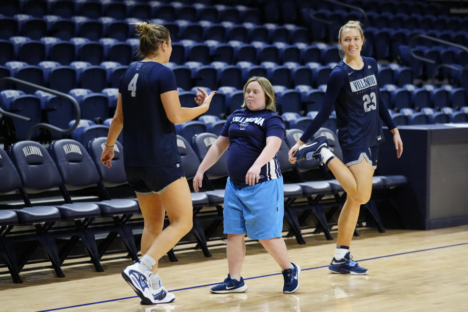 Villanova's Kaitlyn Orihel, left, greets team manager Rachel Grace, center, as Maddie Burke looks on, during the NCAA college basketball team's practice, March 22, 2023, in Villanova, Pa. Villanova coach Denise Dillon said Thursday that Grace is "every bit a part of our program to the highest level." (AP Photo/Matt Rourke)