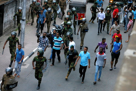 Members of Sri Lanka's Special Task Force and the police chase away supporters of Sri Lanka's newly appointed Prime Minister Mahinda Rajapaksa after an official security guard of sacked minister Arjuna Ranatunga shot and wounded three people in front of the Ceylon Petroleum Corporation, in Colombo, Sri Lanka October 28, 2018. REUTERS/Dinuka Liyanawatte