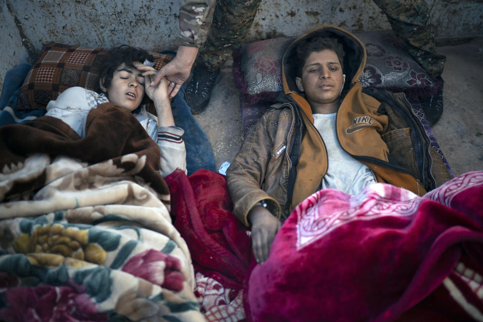 Two injured boys suspected of being Islamic State supporters lay on the back of a truck at a U.S.-backed Syrian Democratic Forces (SDF) screening area after being evacuated out of the last territory held by Islamic State militants, in the desert outside Baghouz, Syria, Friday, March 1, 2019. (AP Photo/Felipe Dana)