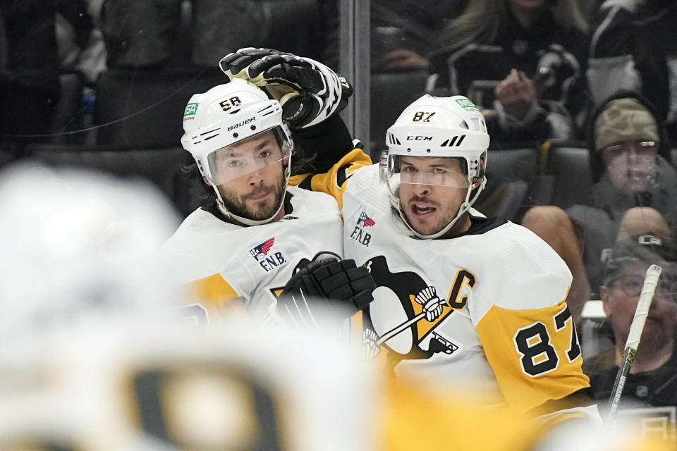 Pittsburgh Penguins center Sidney Crosby, right, celebrates his goal with defenseman Kris Letang during the first period of an NHL hockey game Thursday, Nov. 9, 2023, in Los Angeles. (AP Photo/Mark J. Terrill)