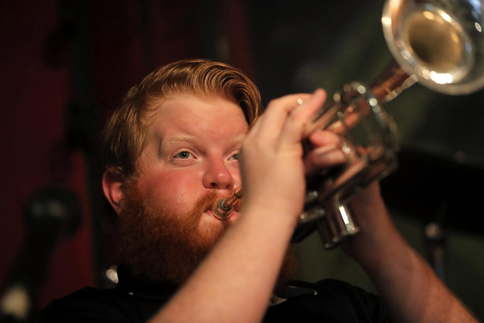 Doyle Cooper plays his trumpet has he performs a livestream gig with his mother, singer Leslie Cooper, and pianist Harry Mayronne, in an empty and closed Back Room at Buffa's in New Orleans, Tuesday, April 28, 2020. (AP Photo/Gerald Herbert)