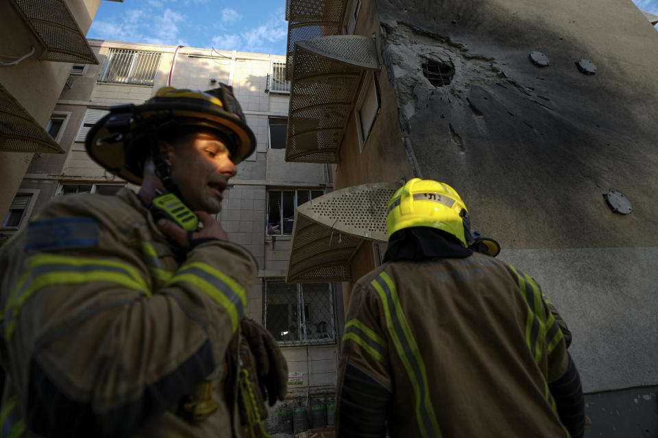 Israeli security forces inspect a damaged residential building after it was hit by a rocket fired from the Gaza Strip, in Sderot, Israel, Tuesday, Oct. 17, 2023. (AP Photo/Ariel Schalit)