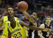 Michigan guard Caris LeVert (23) and Wofford guard Jaylen Allen battle for a rebound during the first half of a second round NCAA college basketball tournament game Thursday, March 20, 2014, in Milwaukee. (AP Photo/Jeffrey Phelps)