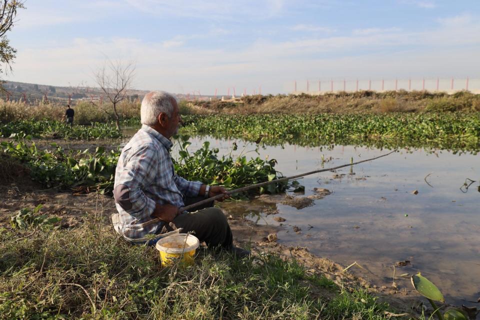 PHOTO: Nafia Sattouf goes fishing in the Orontes River, where the Nile flower covers much of the surface, in Idlib province, northwestern Syria, on Nov. 30, 2023. (Abdul Razzaq Al-Shami/ABC News)