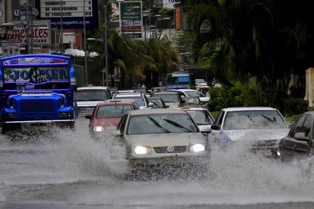Vehicles drive through a street flooded by heavy rains caused by tropical storm Carlos, in Acapulco, Mexico, June 14, 2015. Tropical storm Carlos threatened Mexico's southwest Pacific coast with heavy rains on Sunday, and is likely to become a hurricane again as it barrels toward land, the U.S. National Hurricane Center (NHC) said. REUTERS/Claudio Vargas