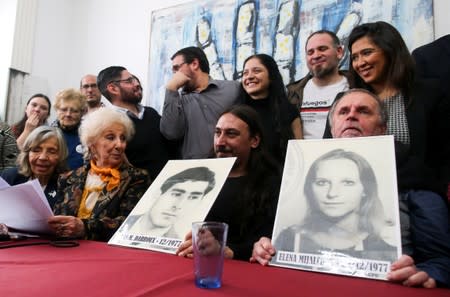 Javier Matias Darroux Mijalchuk, son of Elena Mijalchuk and Juan Manuel Darroux, who disappeared during Argentina's former 1976-1983 dictatorship, holds an image of his father, during a news conference in Buenos Aires