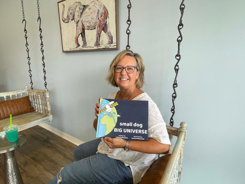 Grace Christian Academy teacher Trista McReynolds shows off her newly written children’s book, “Small Dog, Big Universe,” in Karns Tuesday, Aug. 8, 2023.